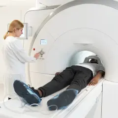 Pacjent leży w aparacie MRI, a technik kontroluje badanie. Choć rezonans magnetyczny jest bezpieczny, warto znać potencjalne skutki uboczne.