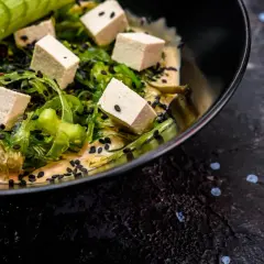 Sałatka z kostkami tofu, wodorostami i czarnym sezamem w kremowym sosie. Czy tofu jest lekkostrawne? Tak, to świetny wybór!
