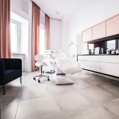 Nowoczesny gabinet dermatologii estetycznej z fotelem zabiegowym i meblami.