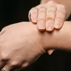 Dłoń z widocznym twardym guzem na wewnętrznej stronie nadgarstka.