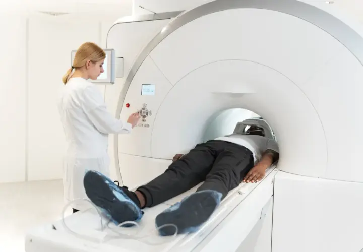 Pacjent leży w aparacie MRI, a technik kontroluje badanie. Choć rezonans magnetyczny jest bezpieczny, warto znać potencjalne skutki uboczne.