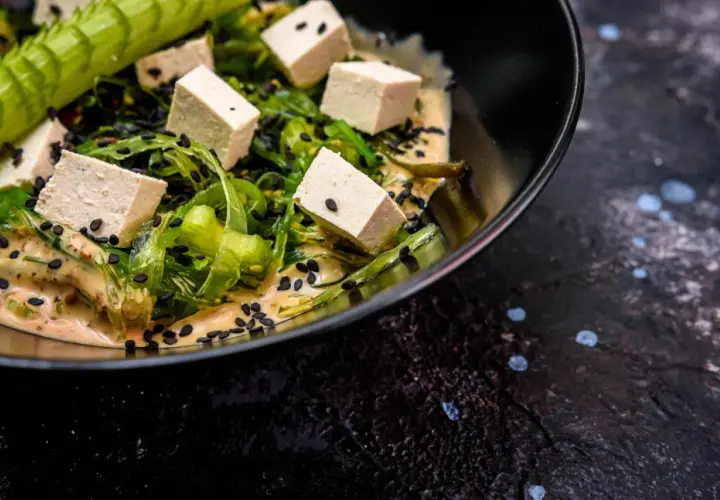 Sałatka z kostkami tofu, wodorostami i czarnym sezamem w kremowym sosie. Czy tofu jest lekkostrawne? Tak, to świetny wybór!