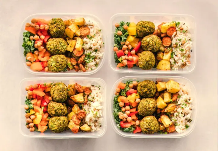 Cztery pojemniki z posiłkami: falafel, ryż, pieczone warzywa i sałatka. Idealny jadłospis na dietę dobrych produktów.