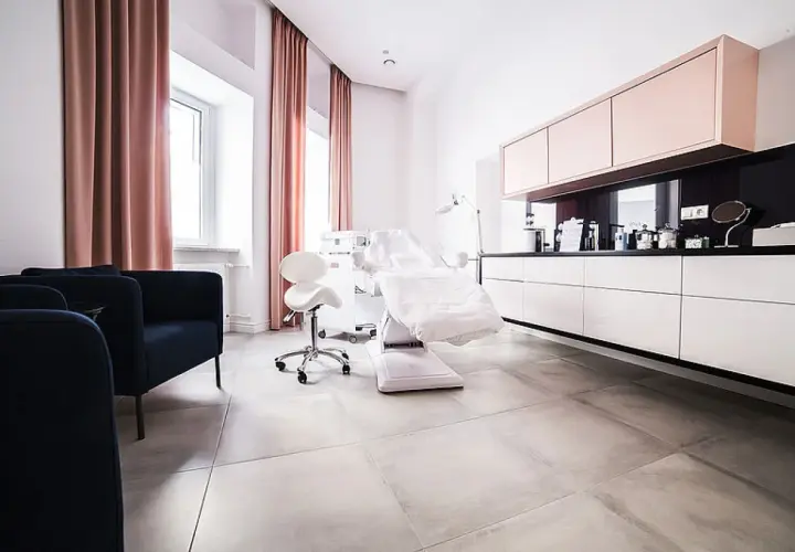 Nowoczesny gabinet dermatologii estetycznej z fotelem zabiegowym i meblami.