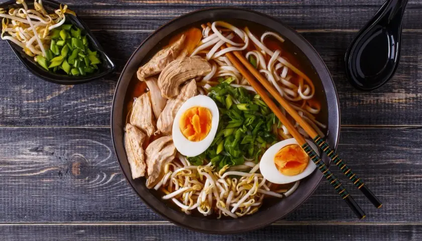 Miseczka aromatycznego ramenu z kurczakiem, jajkiem i kiełkami fasoli. Czy ramen jest zdrowy? Zależy od składników, ale ten wygląda apetycznie i pożywnie.