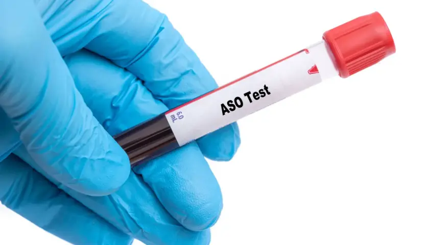 Ręka w niebieskiej rękawiczce trzyma probówkę z napisem "ASO Test". Wysokie ASO może wskazywać na infekcję, a niekoniecznie na nowotwór.