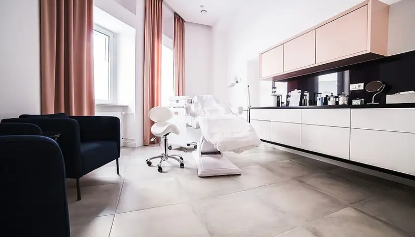 Nowoczesny gabinet dermatologii estetycznej z fotelem zabiegowym i meblami.