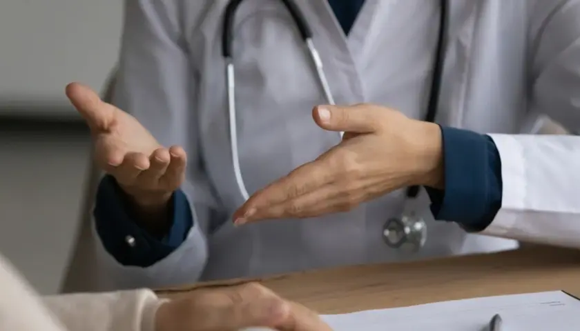 Lekarz omawia z pacjentem objawy, w tym uporczywy kaszel, który może być symptomem raka płuc.