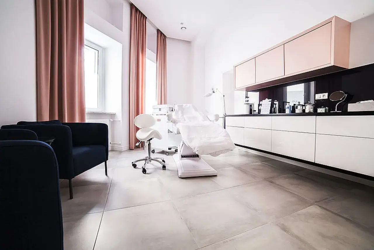 Nowoczesny gabinet dermatologii estetycznej z fotelem zabiegowym i meblami.