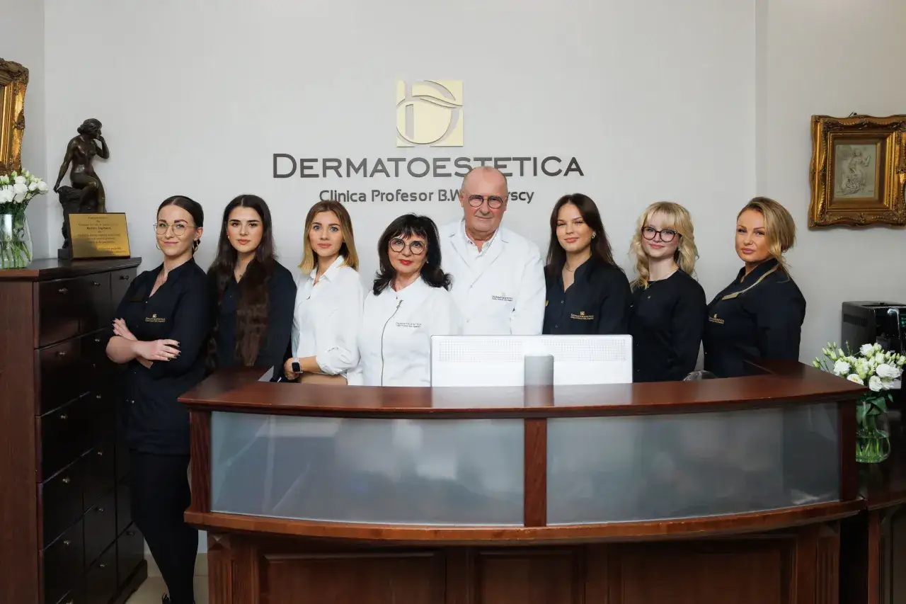 Zespół kliniki dermatologii estetycznej pozuje za ladą recepcyjną.