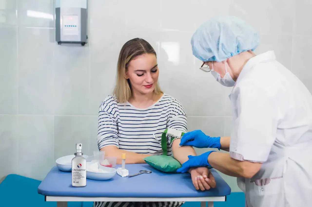 Pielęgniarka pobiera krew od pacjentki. Aby nie zemdleć przy pobieraniu krwi, warto zastosować się do kilku prostych zasad.