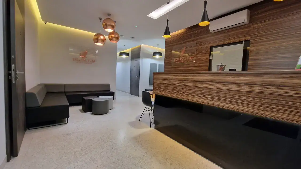 Nowoczesne wnętrze recepcji kliniki medycznej z kanapą, stolikami i ladą.