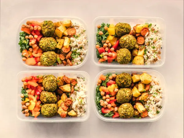 Cztery pojemniki z posiłkami: falafel, ryż, pieczone warzywa i sałatka. Idealny jadłospis na dietę dobrych produktów.